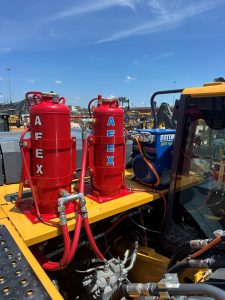 Two red fires suppression system tanks installed on landfill equipment