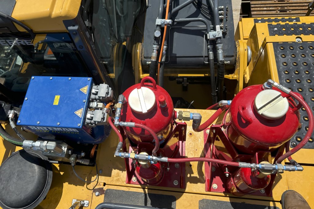 Two red fires suppression system tanks installed on landfill equipment