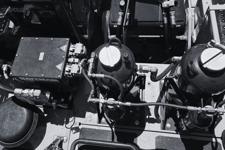 Two fire suppression system tanks installed on landfill equipment in black and white