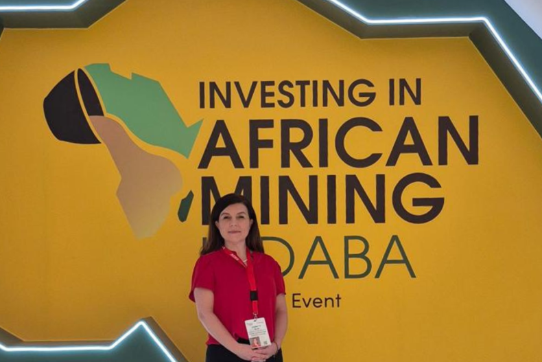 A woman in a red shirt attending Investing in African Mining Indaba event